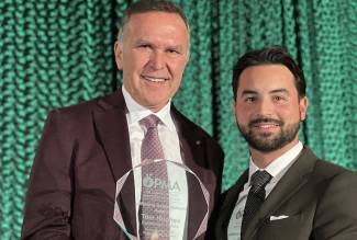 Tom Hughes, president of EarthFresh Farms (left), accepts the Lifetime Achievement Award from Andrew George, EarthFresh Farms. Photo by Grocery Business Magazine. 