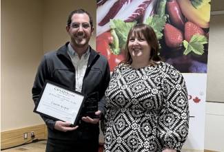 Cameron Korpan receives the Sheri Nielson Auditor Recognition Award from the 2024 winner, Danni Kneeland.