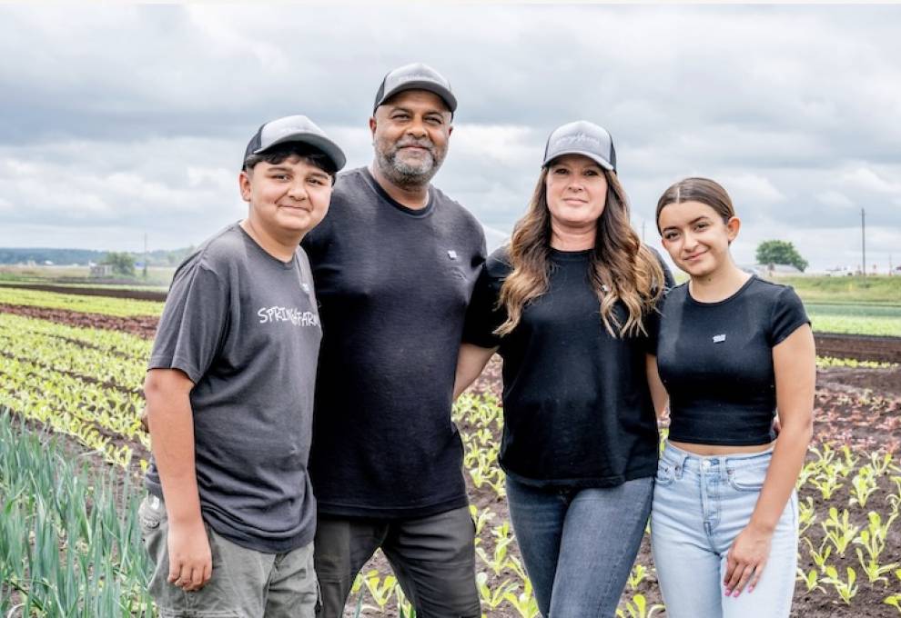Shane Singh and his wife Jennifer, along with their children Nathan and Lauren, pause for a moment in their field of leeks and lettuce near Bradford, Ontario. Photo by Paul Novosad. 