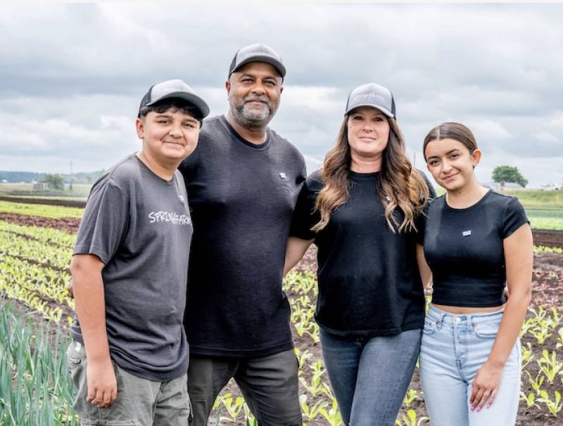 Shane Singh and his wife Jennifer, along with their children Nathan and Lauren, pause for a moment in their field of leeks and lettuce near Bradford, Ontario. Photo by Paul Novosad. 