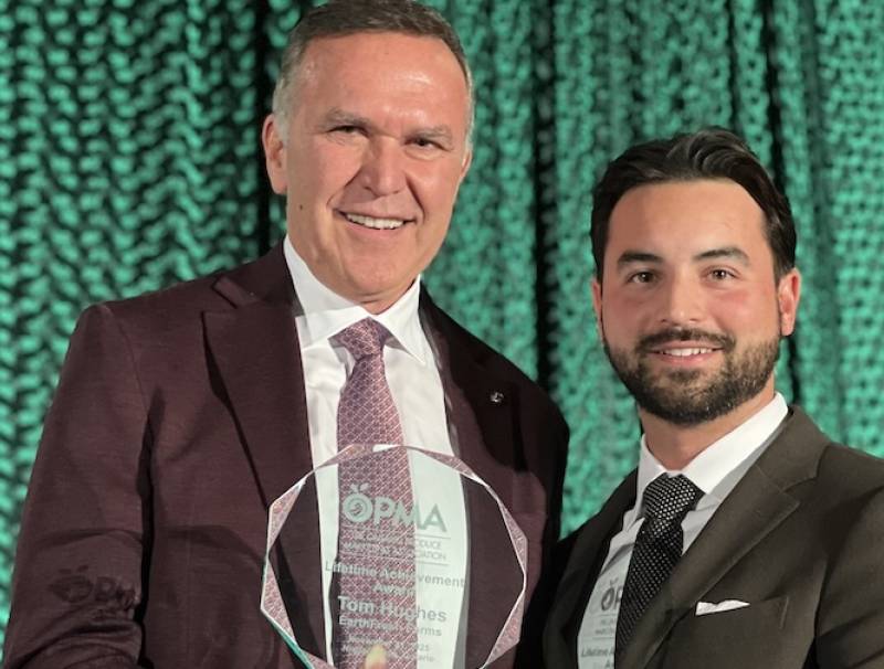 Tom Hughes, president of EarthFresh Farms (left), accepts the Lifetime Achievement Award from Andrew George, EarthFresh Farms. Photo by Grocery Business Magazine. 