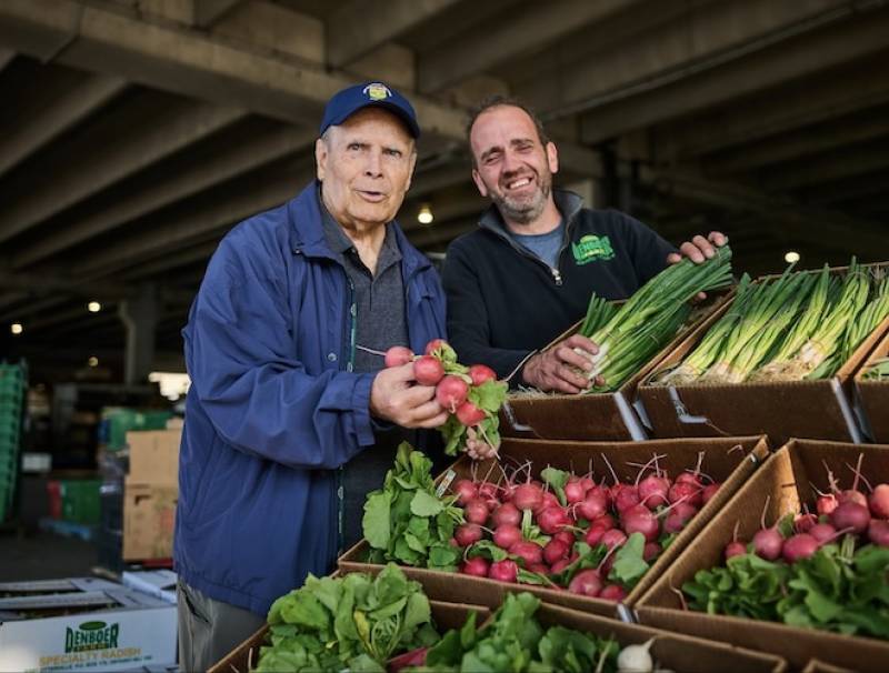 Bruce Nicholas, (L), marking 25 years as the Ontario Food Terminal general manager, is in planning mode as he admires the fresh vegetables of Raymond den Boer, Otterville, Ontario.Photo by Sammy Kogan. 